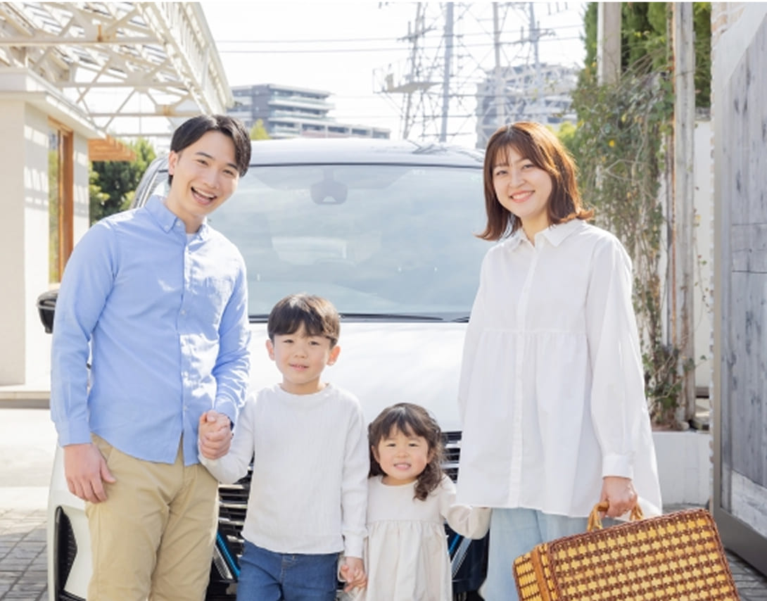 車の前で笑顔で移る家族の写真